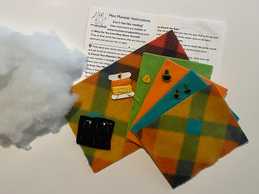 Plaid fabric squares with buttons and a piece of cotton on a white background